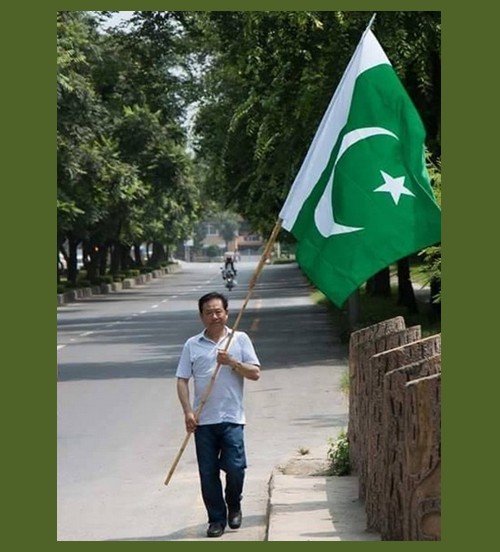 Pakistan's Flag Pictures - A Chinese Man holding Pak flag in Islamabad - Images of Pakistani Flags