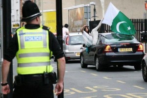 Pic of Girls waving Pakistani flag in a street in London, Great Britain. Celebrating Pakistan's Independence Day