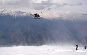 Siachin Pictures: A helicopter landing at a post in Siachin, a soldier guiding the chopper, an orange color windsock also visible - Photos, Images of Siachin
