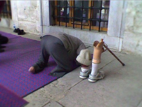 Namaz Pictures - A handicapped man offers Namaz, while his artificial limbs are near by - Namaz Photos