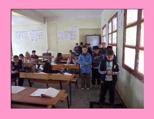 Namaz Pictures - Students offer Namaz in the class room, one student is leads the prayers - Namaz Photos