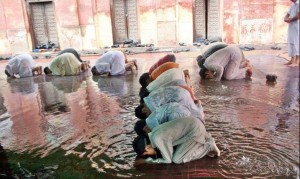 Namaz Photos - People offering Namaz in a mosque flooded with rain water - Namaz (Salat) Pictures