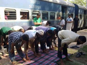 Namaz (Salat) Pictures - Muslims are offering Namaz at a Railway platform while the train is near by - Namaz Photos