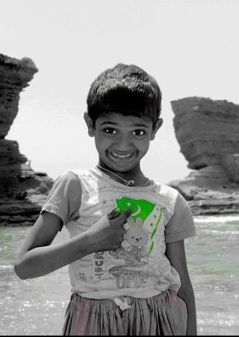 Pakistan Flag Lovers - A boy at Paradise Point Karachi is pointing towards his shirt which has a Pakistani flag - Proud Display of Pakistani flag Proud Display of Pakistani Flag - A proud little boy at Paradise Point Karachi is smiling & pointing towards his shirt which has a Pakistani flag - Pakistani Flag Lovers