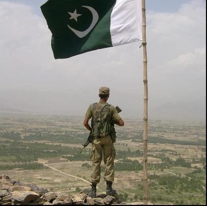 Pakistan Flag Lovers - A soldier guarding border post under a waving Pakistani flag - Display of Pakistani flag Proud Display of Pakistani Flag - Photo of a soldier guarding border post under a waving Pakistani flag - Pakistan Flag Lovers