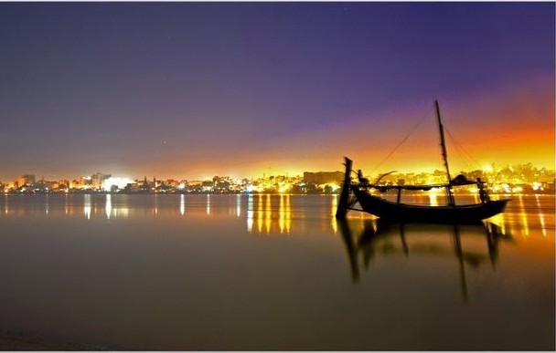 Sukkur Photos - A night view of River Indus and Sukkur City - Sukkur Pictures Sukkur Pictures: A serene night view of River Indus with a boat and Sukkur City in the background - Images, Photos of Sukkur