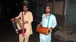Ramzan (Ramadan): Two persons waking Muslims for sehri (suhoor) by beating drum and playing harmonium.